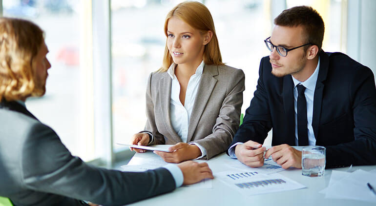 Man and woman interviewing a man